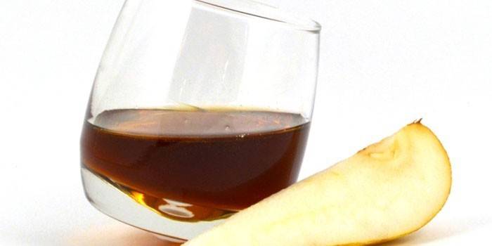 Bumbieris Calvados glāzē un bumbiera šķēle