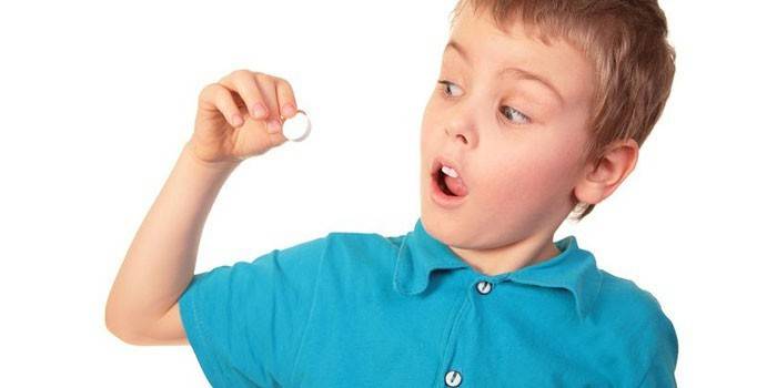 Niño con una pastilla en la mano