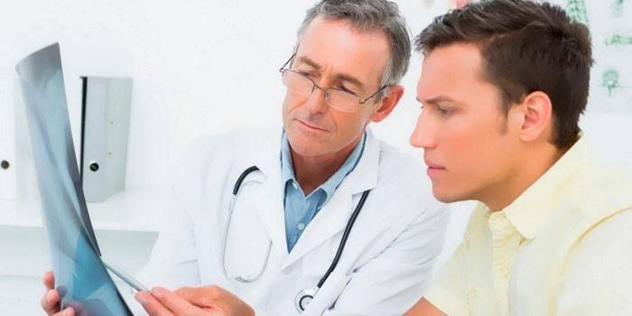 O médico mostra os raios-x do paciente