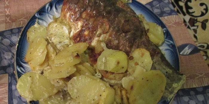 Carpa cruciana al horno con papas en un plato