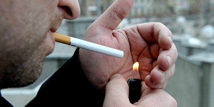 Vyras užsidega cigaretę