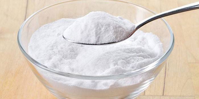 Bicarbonato di sodio in un piatto e cucchiaio