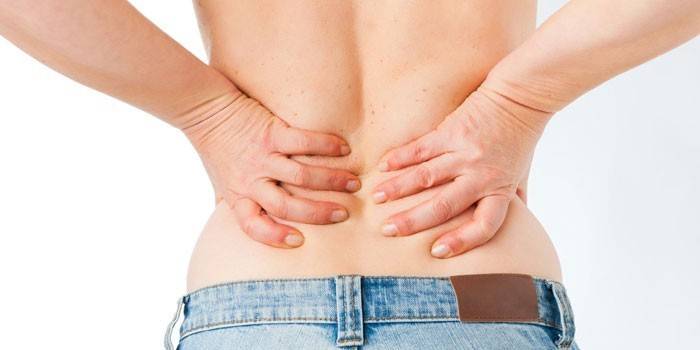 Người phụ nữ đặt tay lên lưng dưới