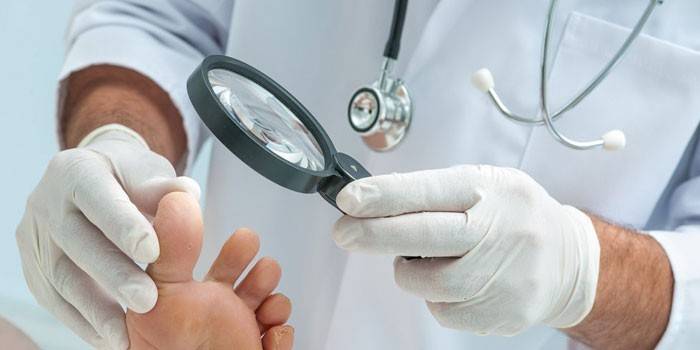 Il medico esamina la gamba del paziente