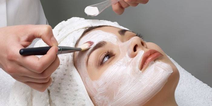 Nag-aaplay ang beautician ng mga produkto ng paglilinis sa mukha ng pasyente