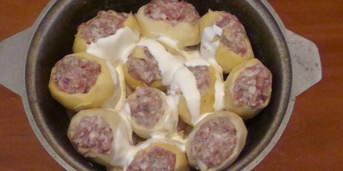 Pommes de terre farcies avec de la viande hachée et de la crème sure dans un chaudron avant la cuisson