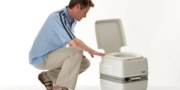 ชายคนหนึ่งศึกษารูปแบบของตู้เสื้อผ้าแห้ง Thetford Porta Potti 365
