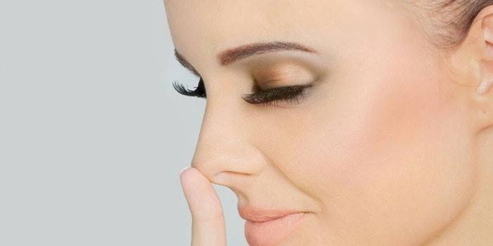 La fille lève le doigt du bout du nez