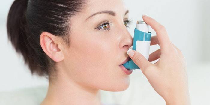 Meitene ar inhalatoru rokās