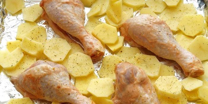 Bulvių griežinėliai ir vištienos gabaliukai prieš kepdami ant kepimo skardos