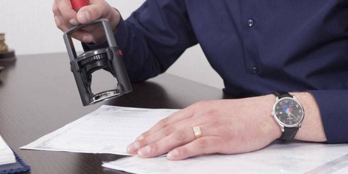 Homem coloca um carimbo em um documento