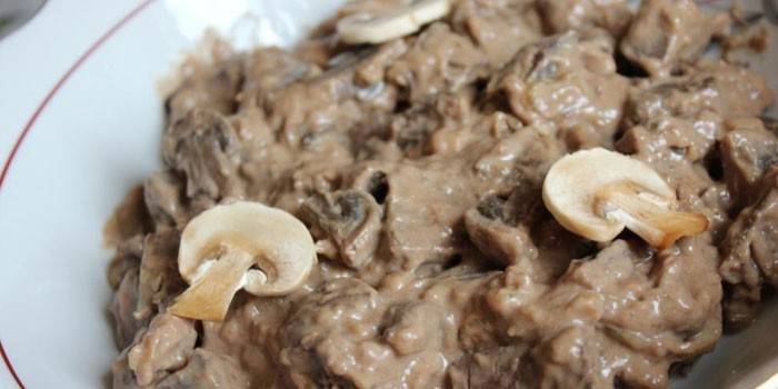 Fatias de carne de porco cozida com cogumelos em molho cremoso