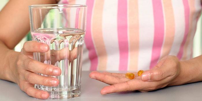 Cô gái với thuốc và một ly nước