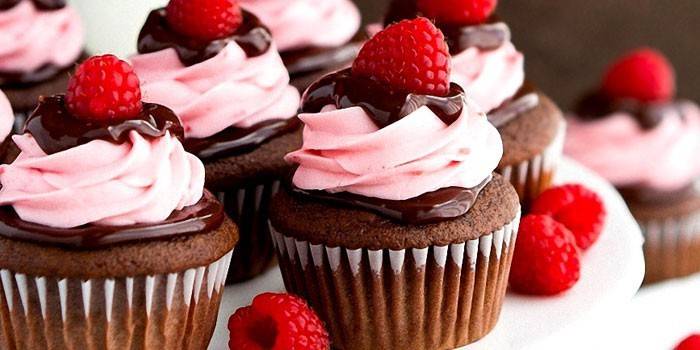 Petits gâteaux au chocolat avec deux sortes de crème et de framboises