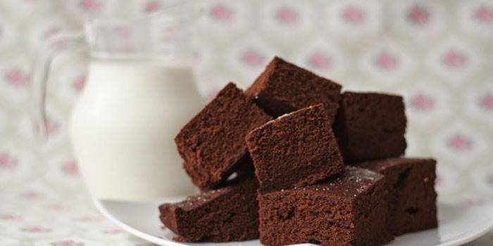 Pedaços de bolo de chocolate e um jarro de leite