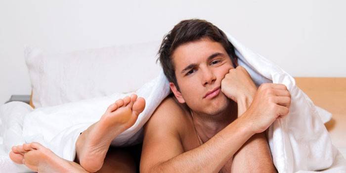 Hombre debajo de las sábanas