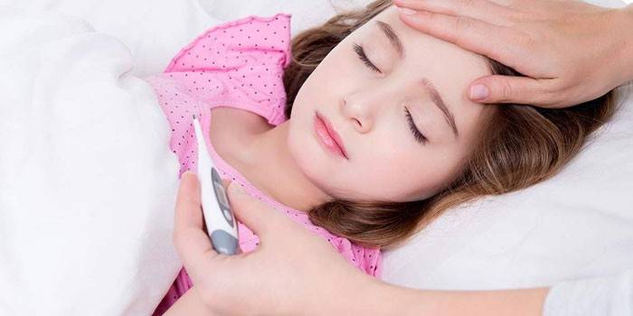 Một người phụ nữ đo nhiệt độ của một cô gái đang ngủ