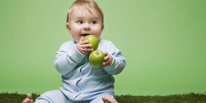 Il bambino tiene le mele