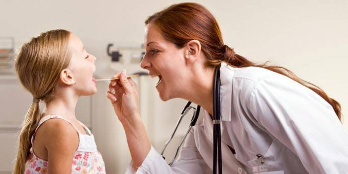 El médico examina la garganta de un niño.