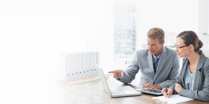 L'uomo e la donna stanno lavorando su un computer portatile.