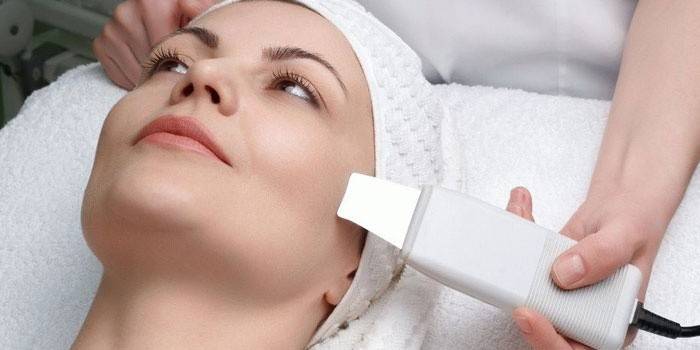 Gumagawa ang beautician ng dry paglilinis ng mukha ng isang babae