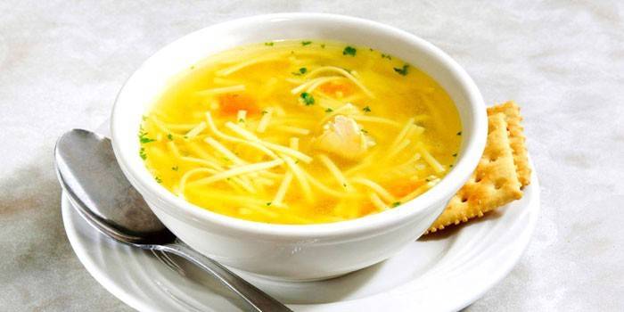 Sopa de galinha com macarrão de ovo em um prato