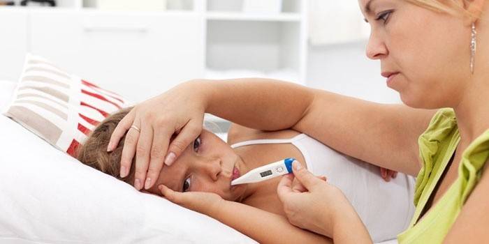 La mamma misura la temperatura del bambino