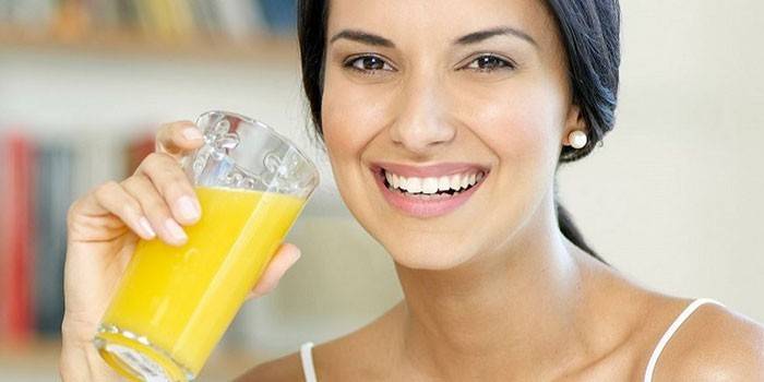 La ragazza beve il succo