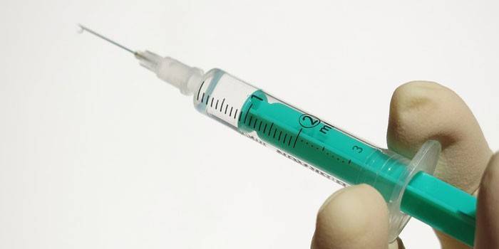 Siringa medica con una sostanza in mano