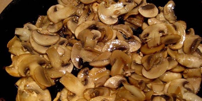 Geschnittene Champignons in einer Pfanne gebraten