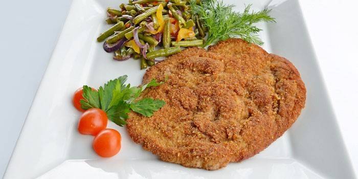 Schnitzel de porc cu salată pe o farfurie