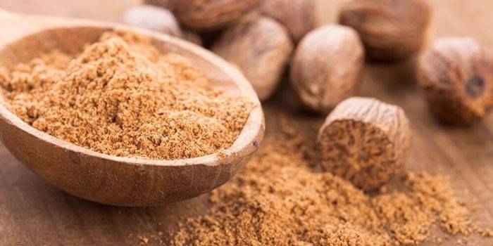 Ground nutmeg in a wooden spoon
