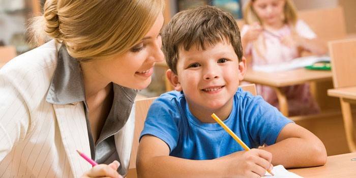 Người phụ nữ và đứa trẻ ngồi ở bàn làm việc