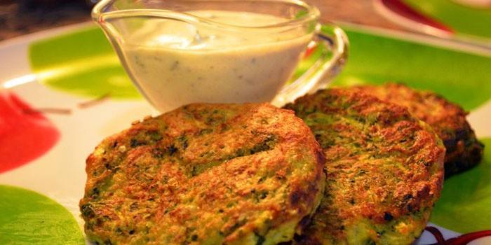Zucchinistückchen auf einer Platte mit Soße