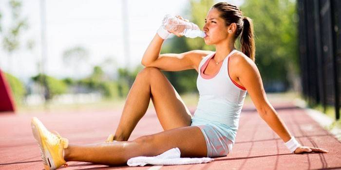 Fille boit de l'eau d'une bouteille