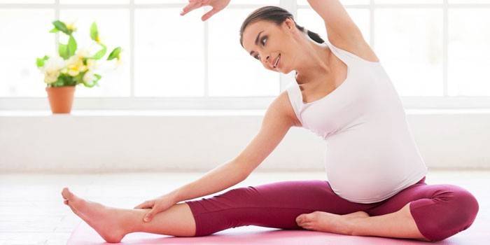 Ragazza incinta che fa i pilates a casa