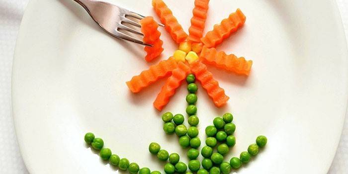 Fleur de carottes et de pois verts sur une assiette