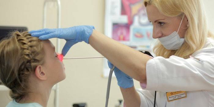 El médico realiza rinoscopia.