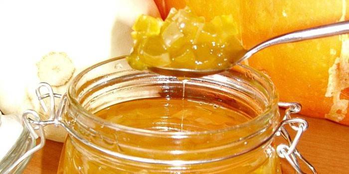 Kürbismarmelade mit getrockneten Aprikosen in einem Löffel und in einem Glas