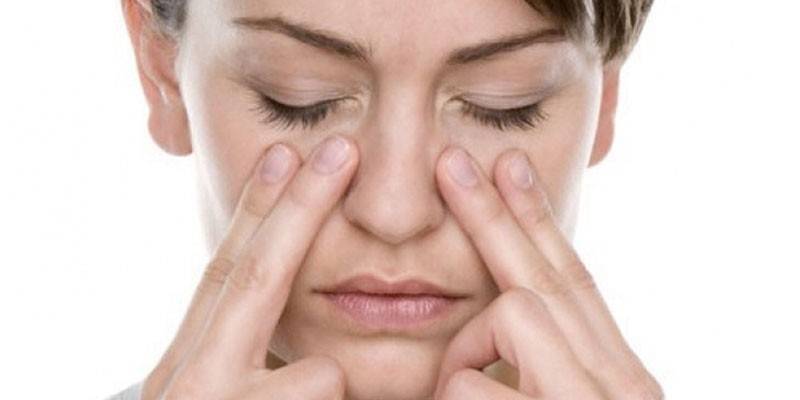 Woman put her fingers to her face