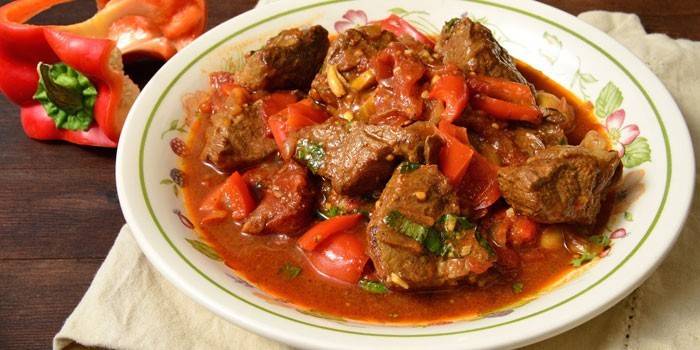 Goulash de carne de porco com legumes e molho em um prato