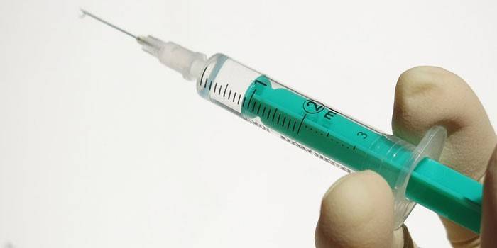 Jeringa médica con un medicamento en mano