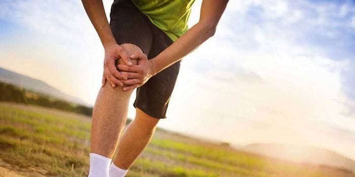 Mann legte die Hände auf sein Knie