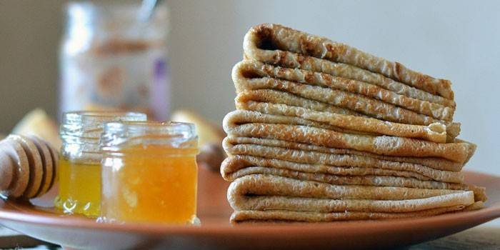 Una pila de creps i un pot de mel