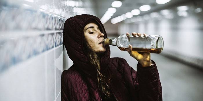 Fata bea whisky dintr-o sticlă din pasaj