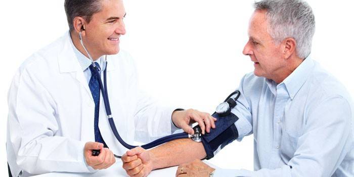 Doktor bir adamın basıncını ölçer