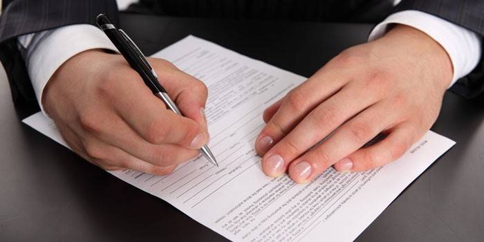 Un hombre llena un contrato