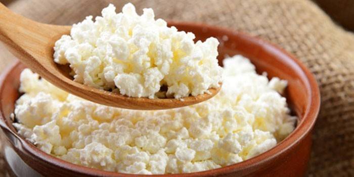 Phô mai trong một cái đĩa và một cái thìa gỗ