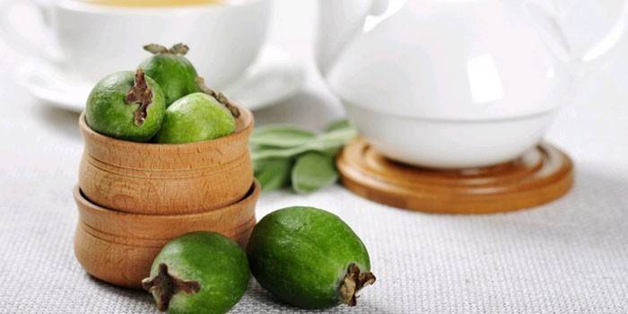 Feijoa-hedelmät puisessa kulhossa ja pöydällä