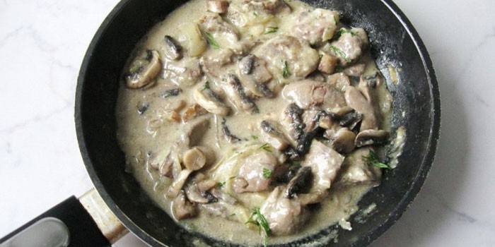 Fetge de pollastre amb bolets en una salsa de crema agria en una paella